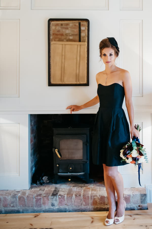 Bridesmaid in blue dress standing by wood burner