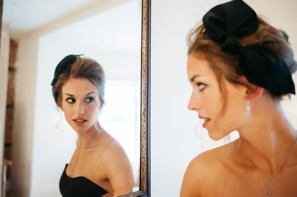 Bridesmaid with hair bow looking in mirror