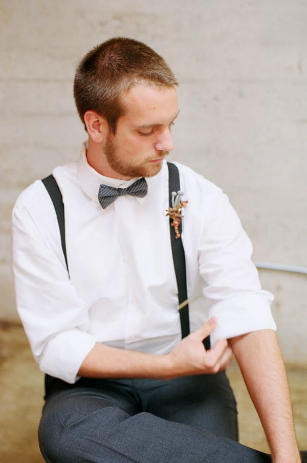 Groom rolling up sleeve