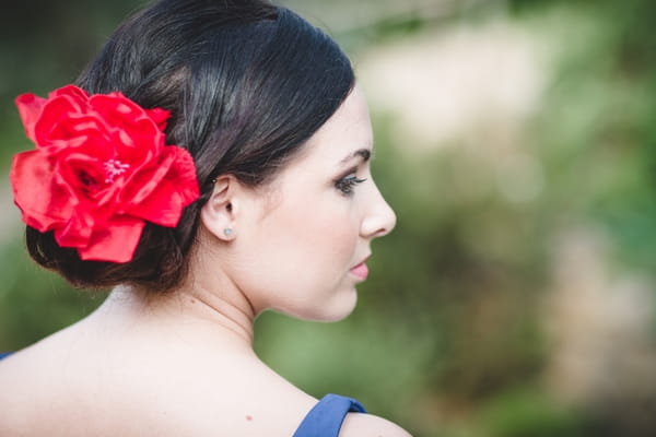 Spanish style bridesmaid with red flower in hair