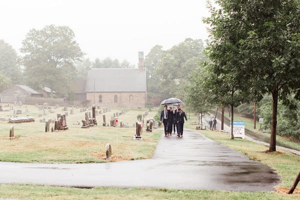 Guests walking to wedding in rain