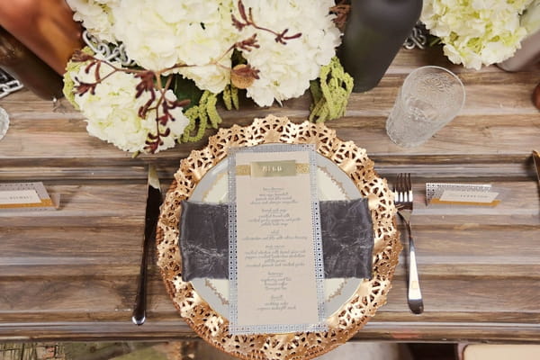 Wedding menu on plate with gold charger