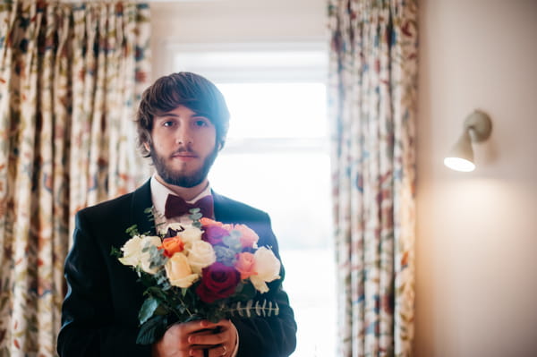 Groom holding bouquet