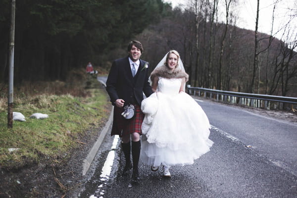 Bride and groom walking down road