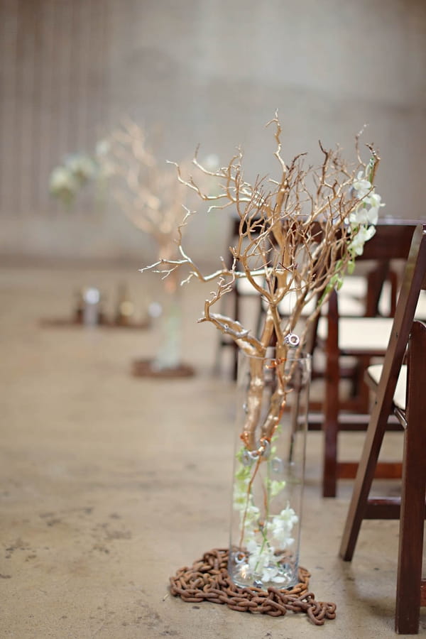 Branches in vases as aisle decoration