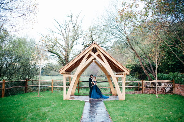 Bride and groom under wooden frame