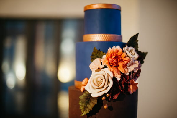 Flowers on blue and gold wedding cake