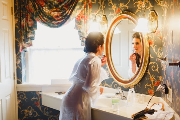 Bride doing make-up in mirror