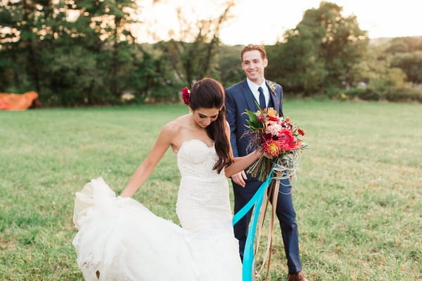 Bride and groom walking across field