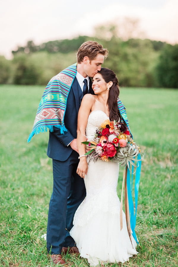 Groom kissing bride on the head