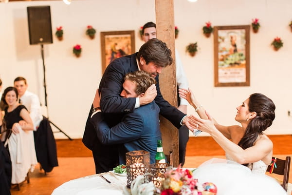 Bride's father hugging groom