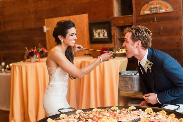 Bride feeding groom paella