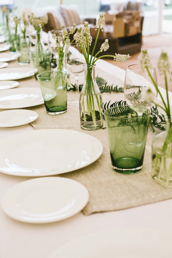 Green glasses and hessian runner on wedding table