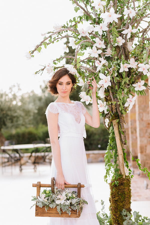 Bride standing next to tree