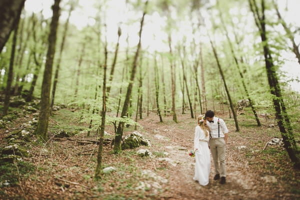 Bride and groom walking in woods