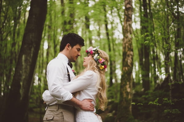 Bride and groom hugging in woods