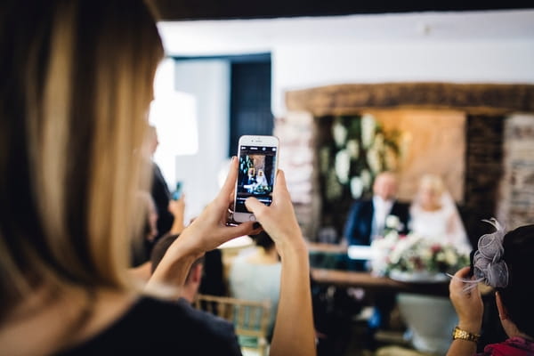 Wedding guest taking picture on phone