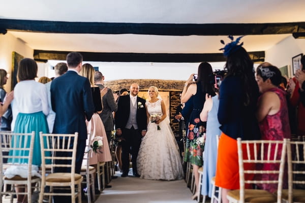 Bride and groom leave wedding ceremony