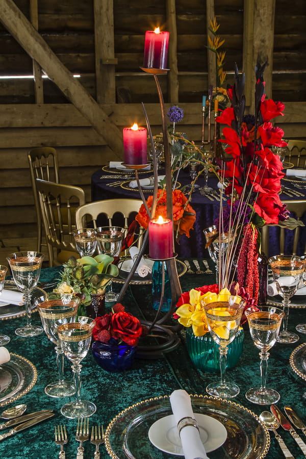 Wedding table with colourful candles, glasses and flowers