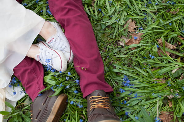 Bride and groom's legs laying on grass