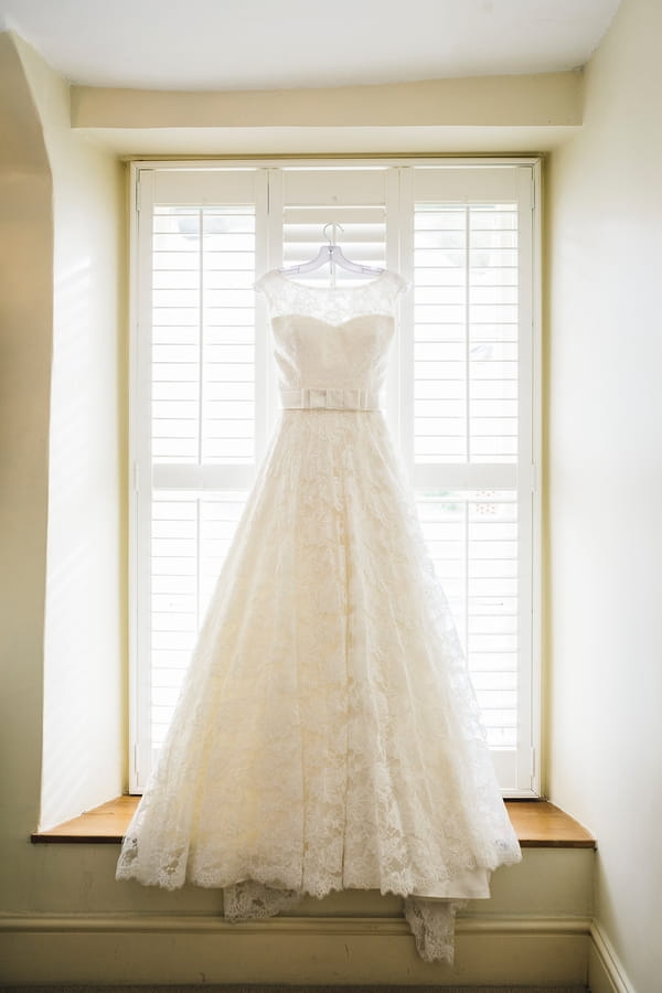 Justin Alexander wedding dress hanging in window