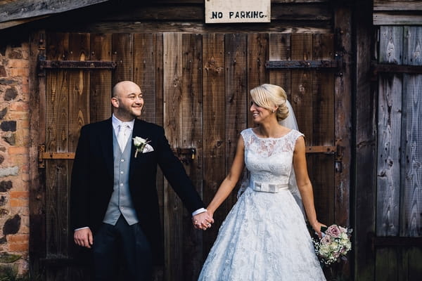 Bride and groom holding hands and looking at each other