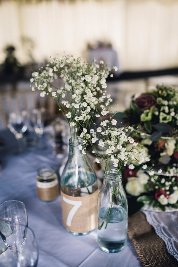 Bottle with flowers for wedding table number