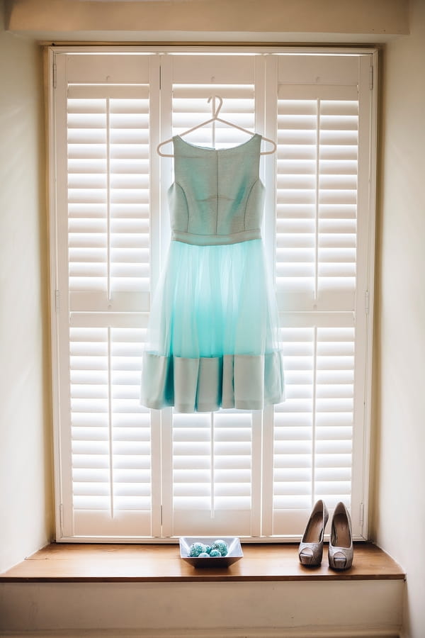 Blue bridesmaid dress hanging in window