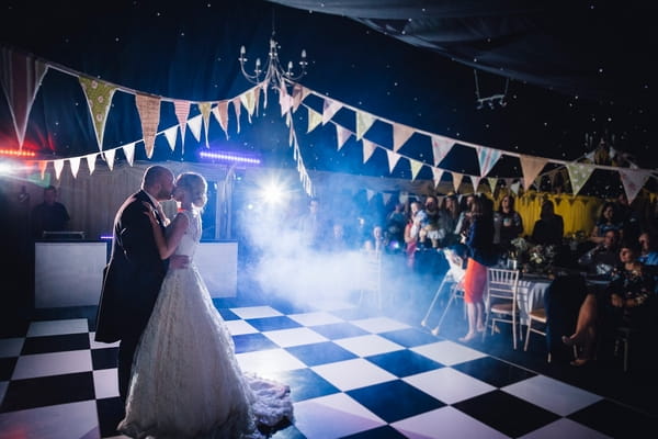 Bride and groom kiss on dance floor