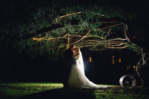 Bride and groom under tree at night