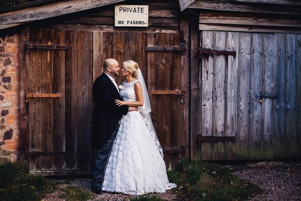 Bride and groom in front of barn door