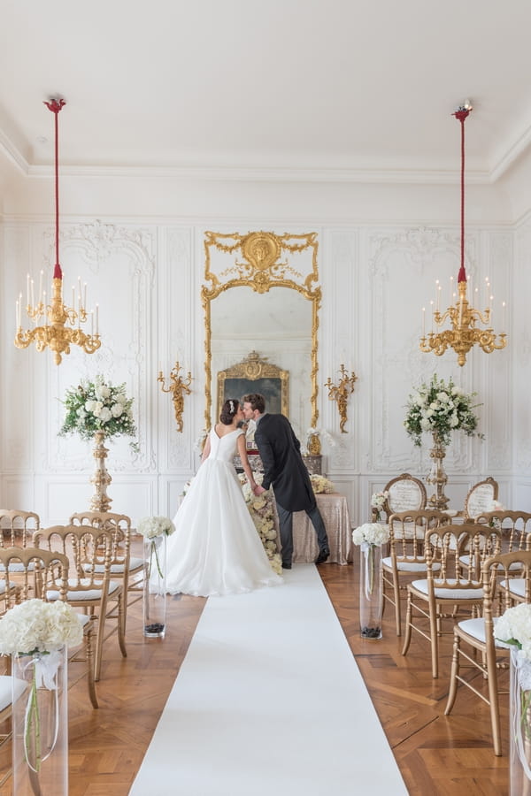 Bride and groom kiss in front of mirror