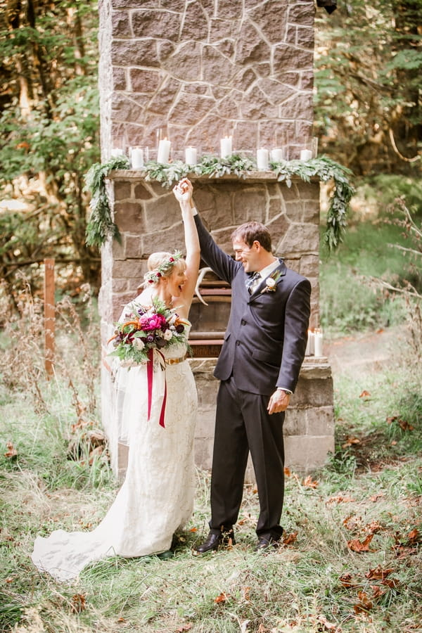 Bride and groom raising arms in the air