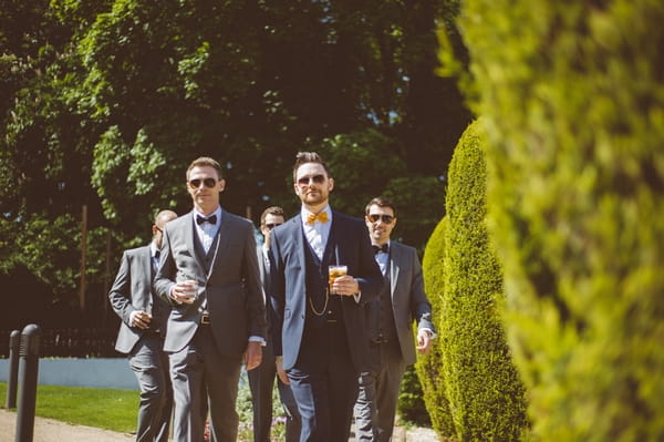 Groomsmen walking with pints