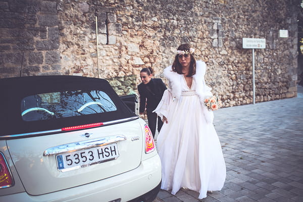 Bride getting out of wedding car