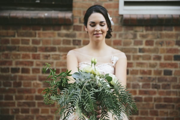 Bride holding wedding bouquet out in front of her