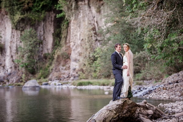 Bride and groom standing on rock