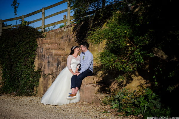 Bride and groom sitting on steps at Huntstile Organic Farm