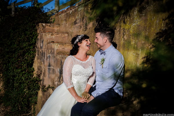 Bride and groom sitting on steps laughing