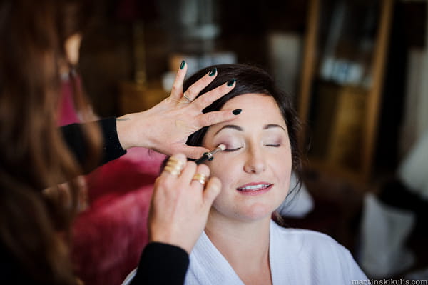 Bride having eye make-up done