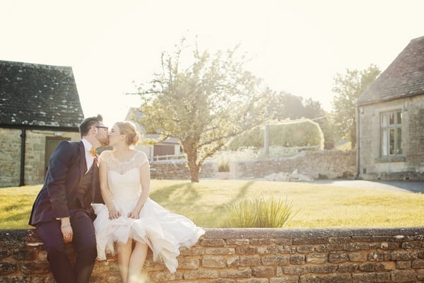 Bride and groom kissing on wall