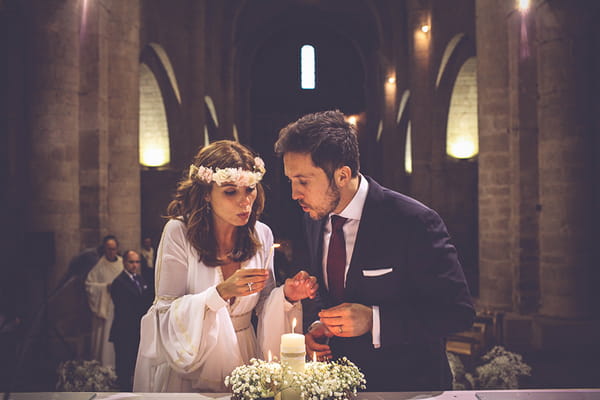 Bride and groom blowing out flame