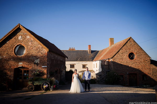 Bride and groom standing in front of Huntstile Organic Farm