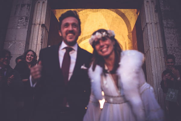 Bride and groom smiling as they leave wedding ceremony