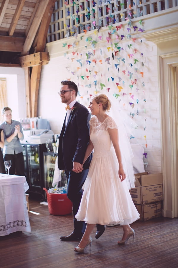 Bride and groom walking in to reception