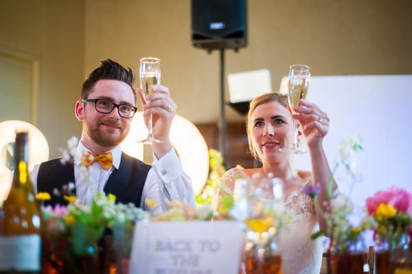 Bride and groom raising glasses