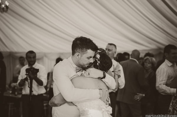 Bride and groom hugging on dance floor