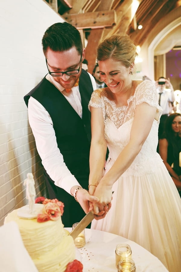 Bride and groom cutting wedding cake