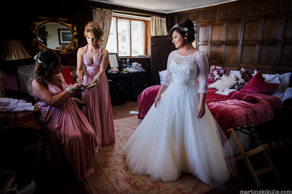 Bride standing in bedroom in wedding dress