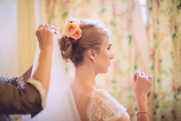 Bride putting veil on